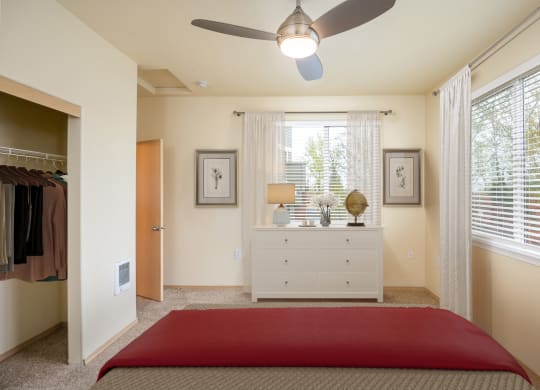 a bedroom with a bed and a dresser and a ceiling fan