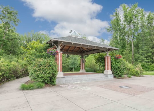 a gazebo with a stone wall and brick pillars