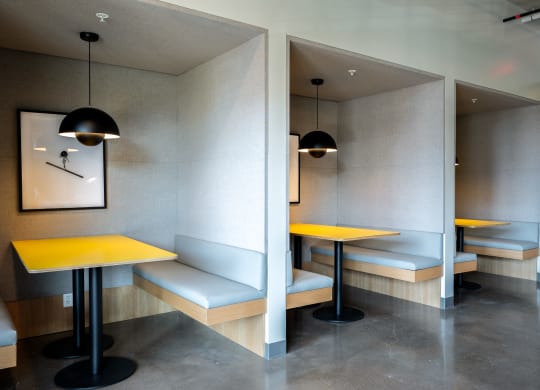 two tables with yellow tops in a room with benches