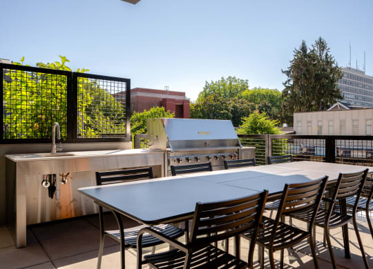 an outdoor patio with a table and chairs and a grill