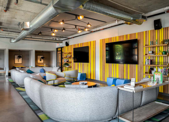 resident lounge room with couches and chairs and two televisions