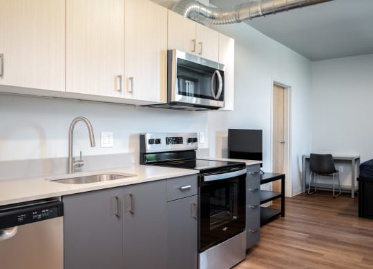 a kitchen with white cabinets and a sink and a microwave
