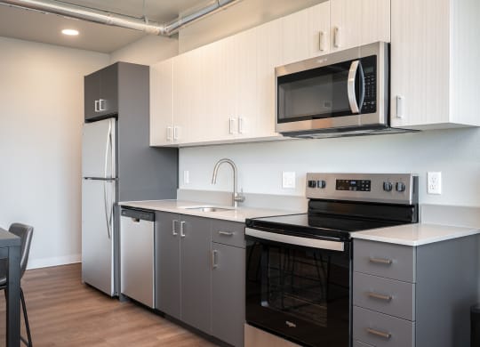 a kitchen with white cabinets and a black counter top