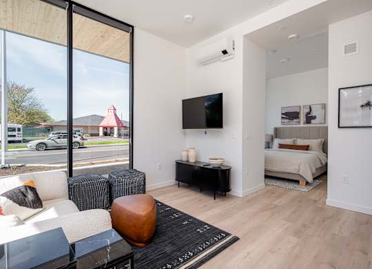 A modern living room with a large window overlooking a street.