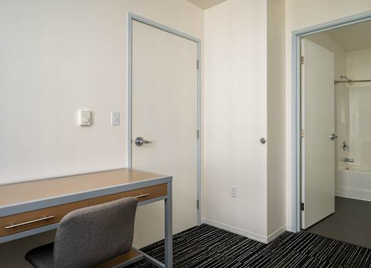 A room with a desk and chair in it.