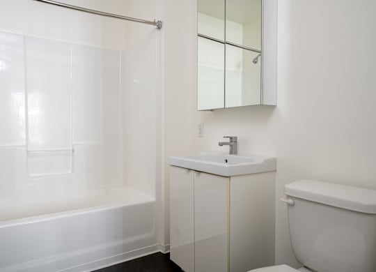 A white bathroom with a sink, toilet, and bathtub.