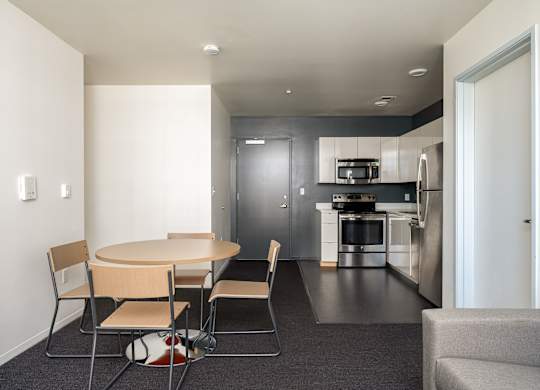 A modern kitchen with a dining table and chairs.