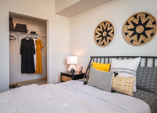 One Bedroom Apartments in Everett WA - The Waterline - Bedroom with Vinyl Hardwood Flooring, Area Rug, Stylish Decor, and Sliding Doors to the Balcony