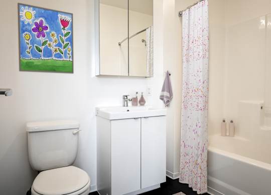 A white toilet sits next to a white sink in a bathroom.