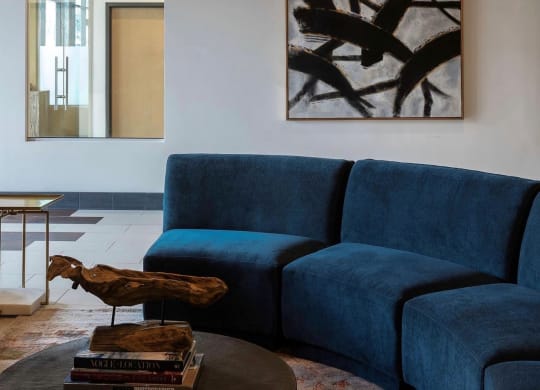 a blue couch in a living room with a table and a bird statue