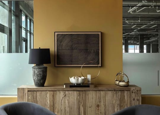 a living room with two chairs and a table and a wooden cabinet