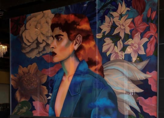 a painting of a woman in a blue suit and a lobby with benches