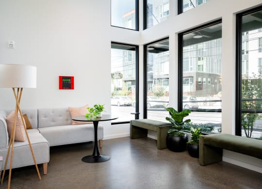 a living room with couches and a table and large windows