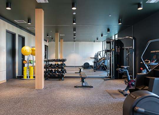 A gym with a variety of equipment including weights and cardio machines.