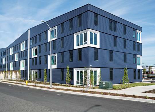 A modern blue building with white trim and windows.