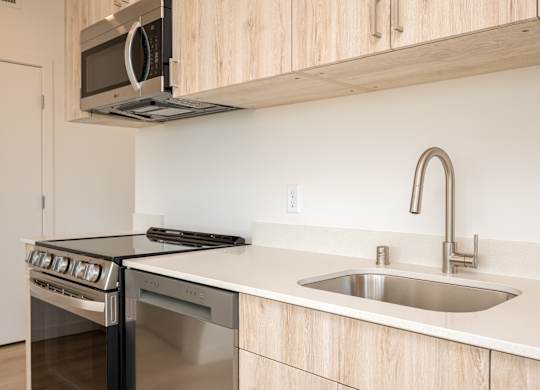 A modern kitchen with a stainless steel oven and microwave above it.