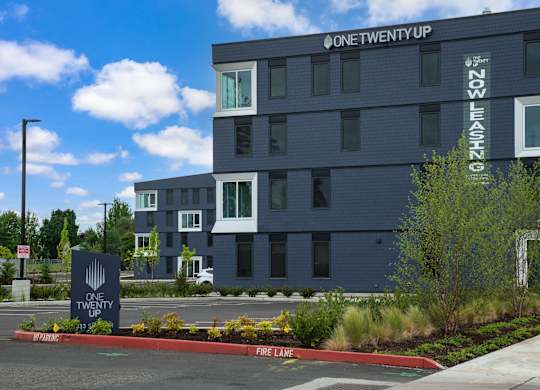 A modern building with the sign "One Twenty Up" on the side.