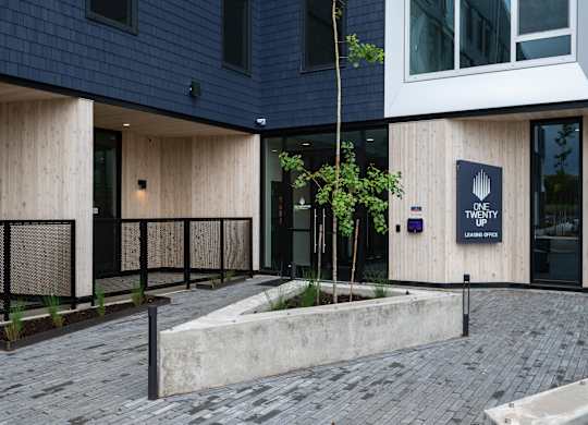 A modern building with a black sign that says "ONE UP".