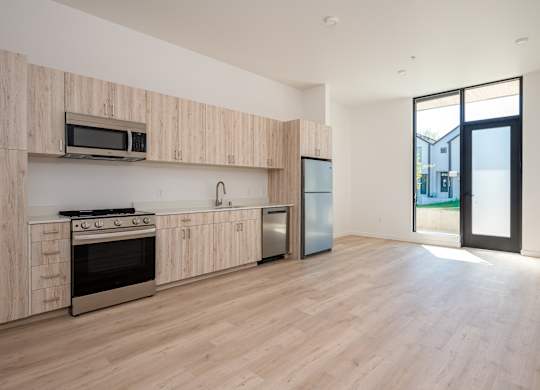 A kitchen with wooden cabinets and a stainless steel refrigerator.