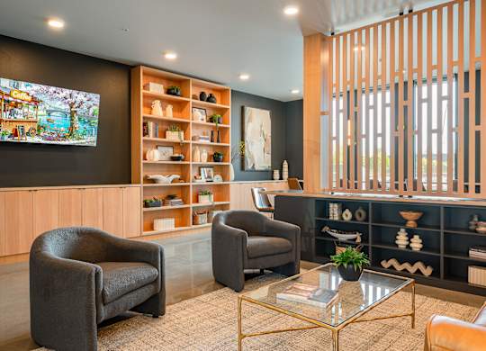 A lounge room with a television, two chairs, and a coffee table.