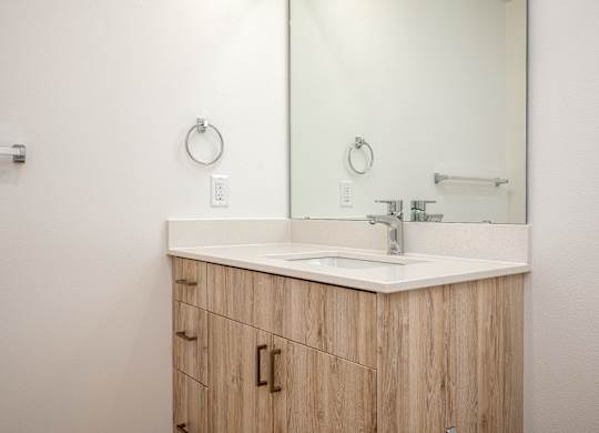 A bathroom vanity with a sink and mirror.