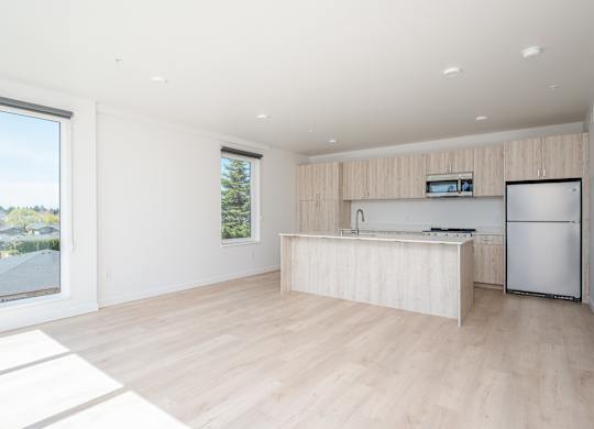 A modern kitchen with a refrigerator, sink, and countertop.