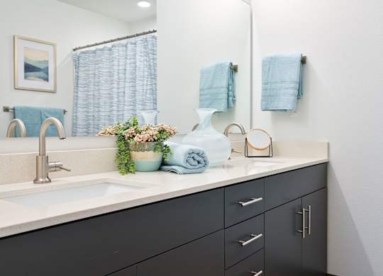A bathroom with a sink, mirror, and towels.