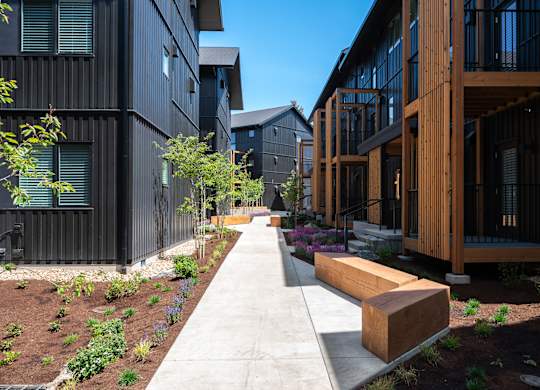 A long concrete walkway leads between two buildings.