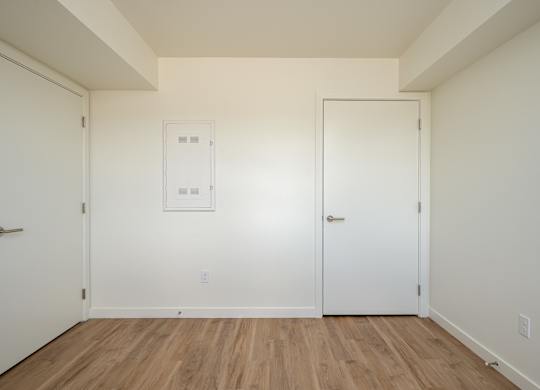 A room with two doors and a white framed window.