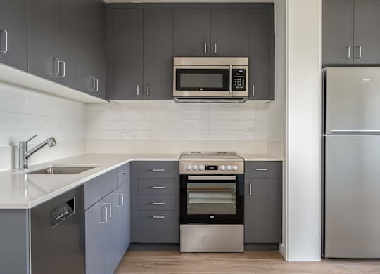 A modern kitchen with a stainless steel refrigerator and a built-in oven.