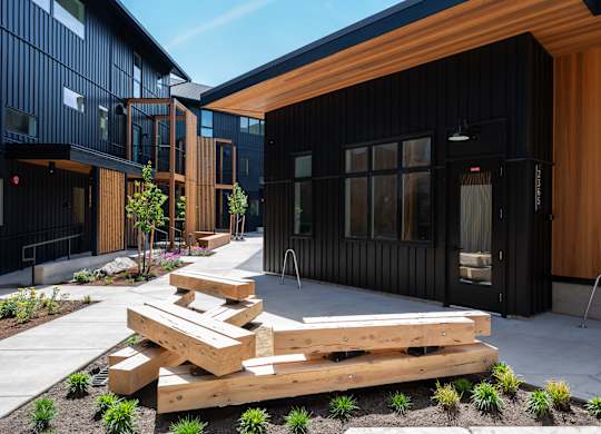 A modern building with a black exterior and wooden accents.
