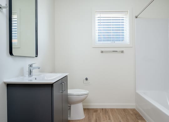A bathroom with a toilet, sink, and bathtub.