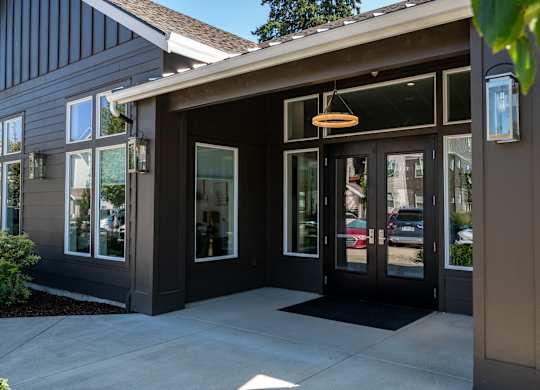 A building with a brown door and a black mat in front.