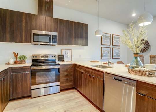A modern kitchen with wooden cabinets and stainless steel appliances.