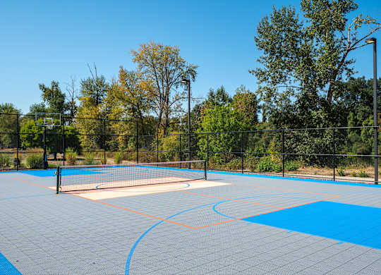 A tennis court with a blue surface and a white net.