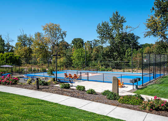 A blue pool surrounded by trees and flowers.