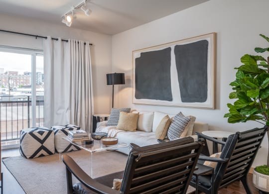 One Bedroom Apartments in Everett WA - The Waterline - Living Room with Vinyl Hardwood Flooring, Area Rug, Stylish Decor, and Sliding Doors to the Balcony