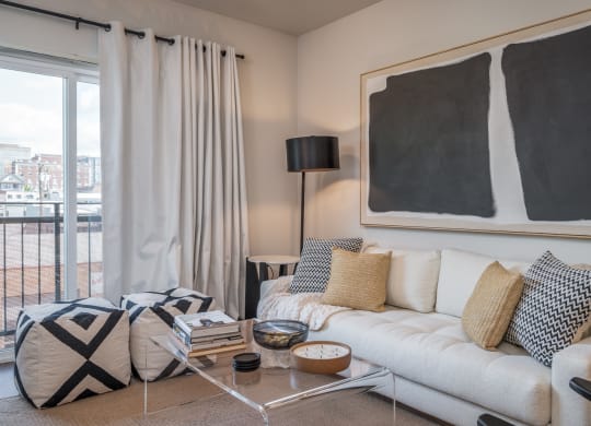 One Bedroom Apartments in Everett WA - The Waterline - Living Room with Vinyl Hardwood Flooring, Area Rug, Stylish Decor, and Sliding Doors to the Balcony