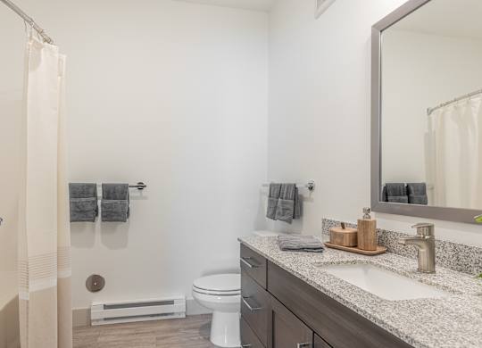 A bathroom with a toilet, sink, and shower.