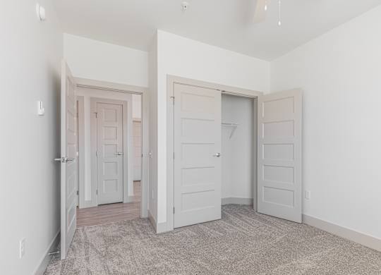 A room with two doors and a carpeted floor.