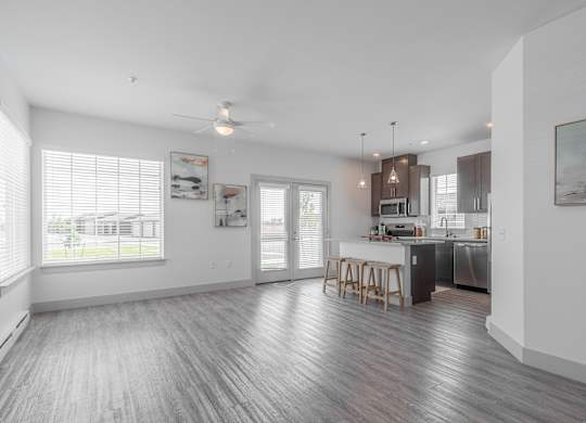 A spacious kitchen and dining area with wooden flooring and white walls.