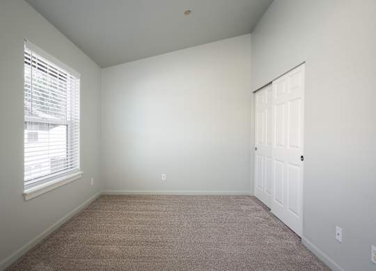 A room with a carpeted floor and a white door.