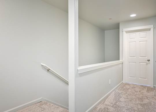 A white door is on the right side of a hallway.