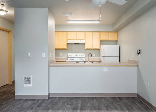 A kitchen with a white fridge and wooden cabinets.