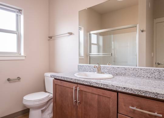 an empty bathroom with a toilet sink and mirror