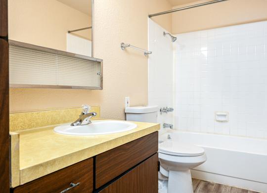 A bathroom with a sink, toilet, and bathtub.