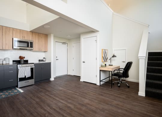 View of studio living room, kitchen and stairway to loft