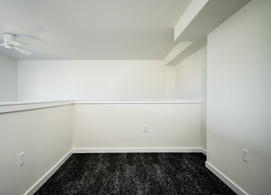 loft room with half wall, dark hardwood floor and white walls