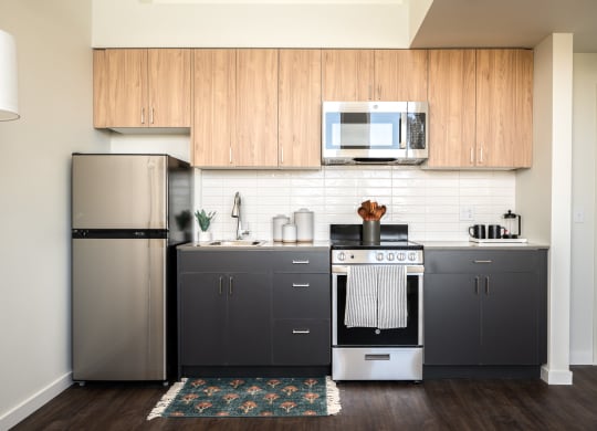 a kitchen with stainless steel appliances and two-tone wooden cabinets