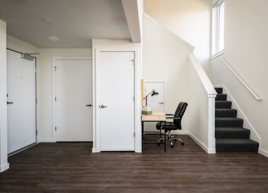 a home office in a home with stairs and a white door